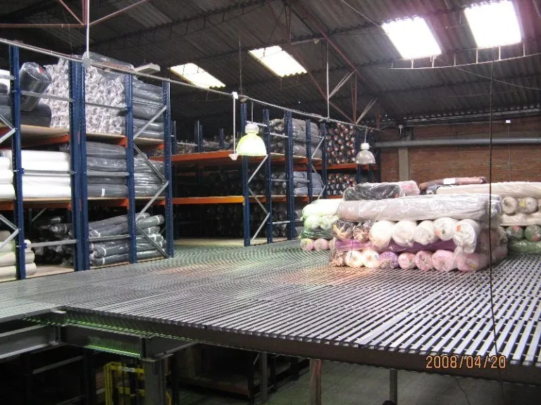 Entreplanta con piso de rejilla para almacenamiento de rollos de tela
