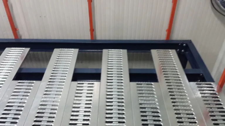 Entreplanta sobre racks en cuarto frío con escalera y barandas