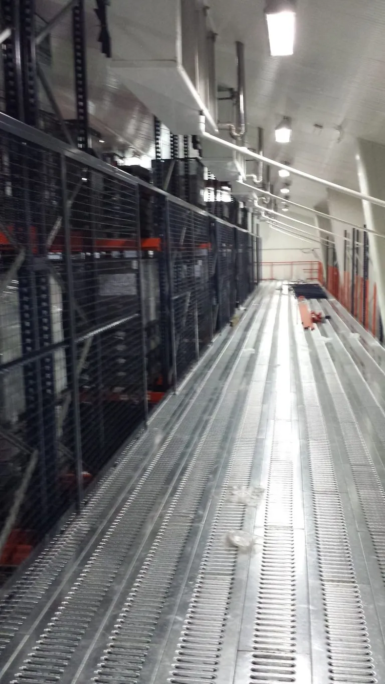Pasarela de piso troquelado entre racks en cuarto frío